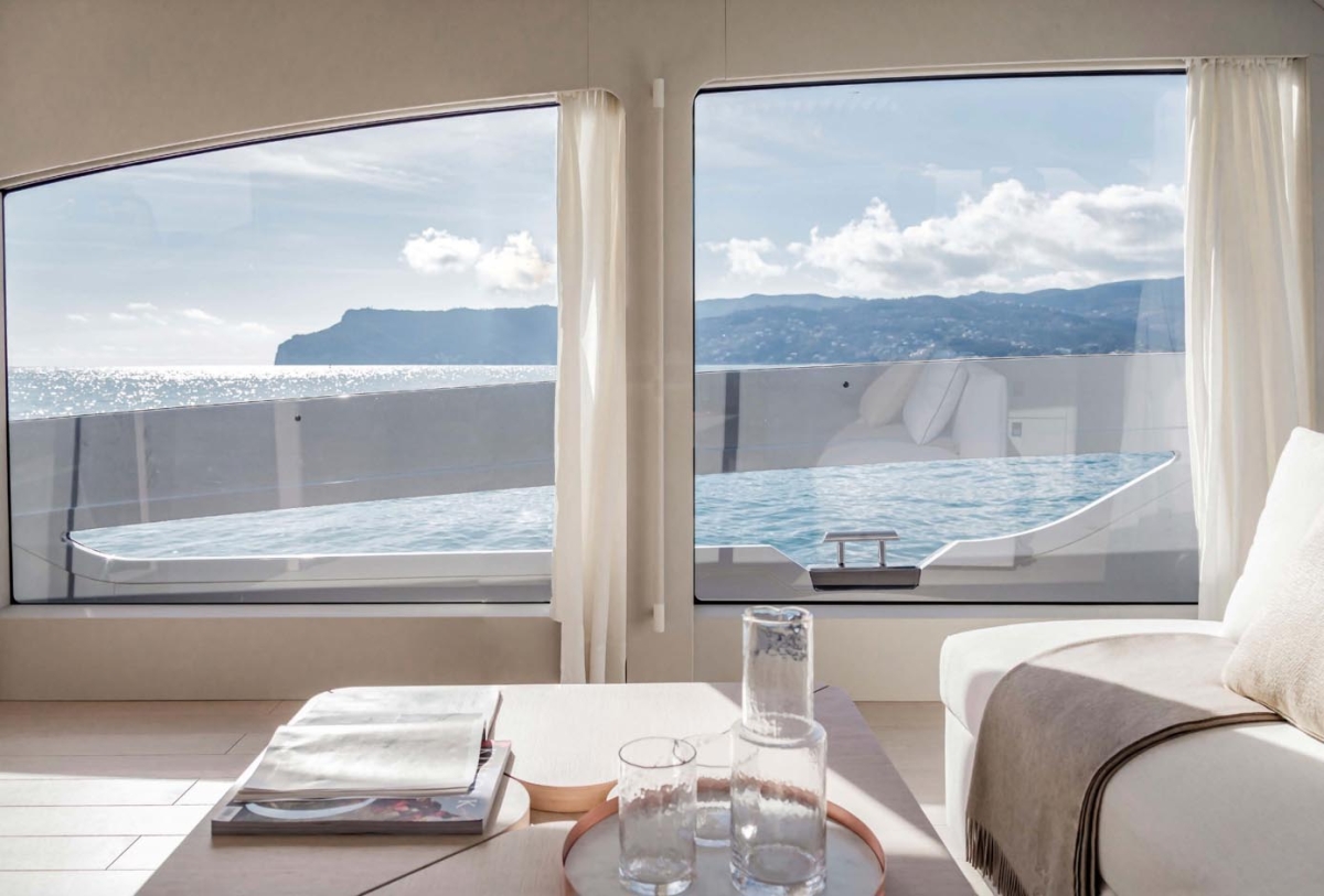 Panoramiczne przeszklenia salonu z widokiem na infinity pool